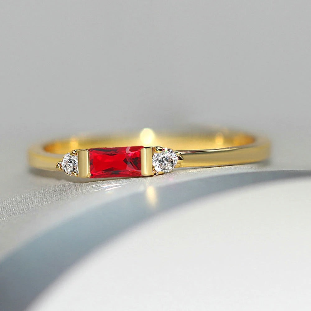 Rød gylden central sten og glitrende ring 